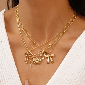 Collier multicouche doré avec pendentifs nœuds et textures de chaînes variées