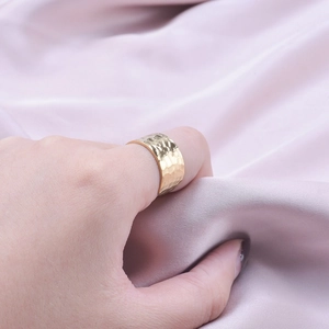 Adjustable wide gold stainless steel ring with hammered texture worn on hand