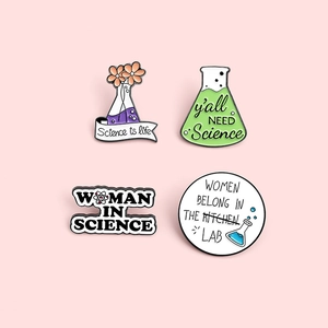 Lot de broches émaillées sur la science avec slogans et fioles sur fond rose pastel