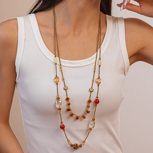 Detail of bohemian double-layer beaded necklace with amber glass and red acrylic beads