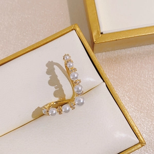 Macro detail of gold layered butterfly ear cuff with pearls and cubic zirconia stones
