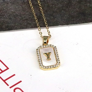 Macro view of rectangular 18K gold letter Y pendant with mother of pearl and zircons