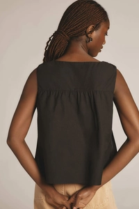 Detail view of the black sleeveless top featuring a pleated patchwork design on the back