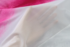 Gros plan sur un tissu en maille blanche montrant texture et transparence sur motif rose