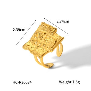 Detailed view of irregular hammered texture gold metal ring measuring 2.74cm x 2.39cm