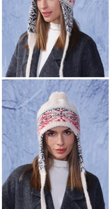 Detail view of winter earflap knit hat with red geometric patterns and faux fur pompom