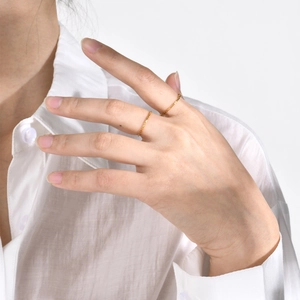 Minimalist stackable gold stainless steel rings worn by model on fingers