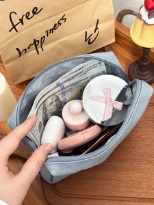 Close-up of gray waterproof cosmetic bag interior holding cosmetics and small accessories