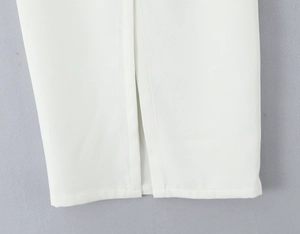 Detailed close-up of white lace fabric texture and slit hem of the elegant skirt