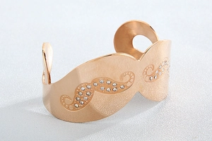 Detail of rose gold wide cuff bracelet with brushed metal and pavé diamond wave pattern