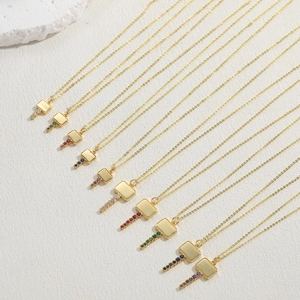 Close-up of gold necklaces with square pendants and multi-color zircon stone drops