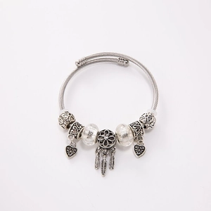 Detail view of silver dreamcatcher charm bracelet with crystal beads and heart pendants