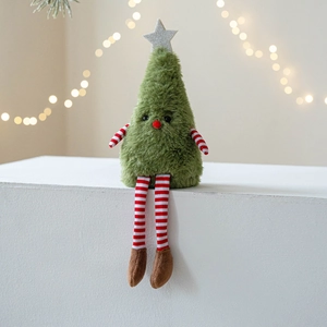 Cute plush Christmas tree doll with long striped legs and star on warm festive background