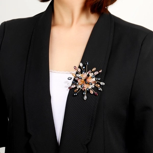 Close-up of snowflake brooch with pearls and crystals on black suit lapel