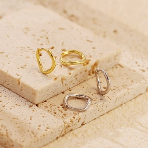 Macro shot of S925 sterling silver stamp on minimalist wave irregular hoop earrings