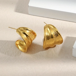 Close-up of 18K gold plated C-shaped earrings with unique crinkled metal texture