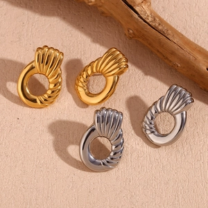 Macro view showing shell-like texture on gold and silver geometric hoop earrings