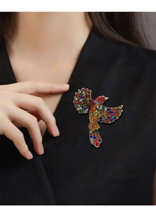 Macro shot of a colorful hummingbird brooch with crystals pinned to a black blazer lapel