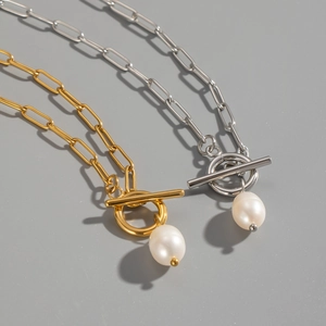 Detail of paperclip link necklaces with toggle clasp and pearl pendant in gold and silver