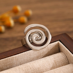 Close-up of a silver spiral ring on a jewelry box with elegant natural lighting