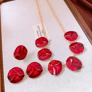 Vintage red enamel pendant necklace and earrings set with gold wave texture detail