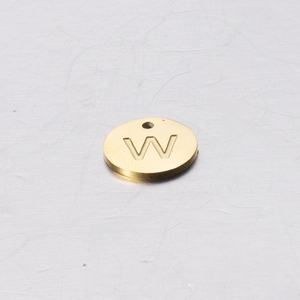 Macro view of a 12mm mirror polished golden stainless steel round pendant with letter W