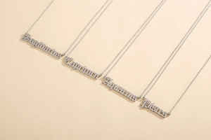 Detail of gothic font constellation name pendants on a silver stainless steel chain