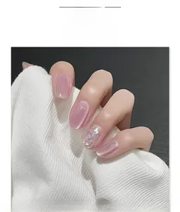 Detail of pink cat-eye press-on nails with silver glitter and rhinestone accents