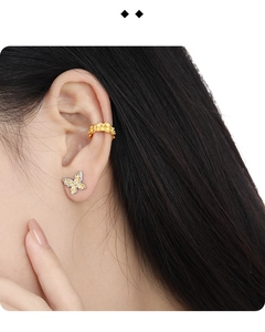 Close-up of mixed metal butterfly stud earring and ear cuff on a model's ear