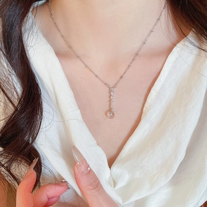 Close-up of elegant zirconia oval hollow pendant necklace worn by a female model