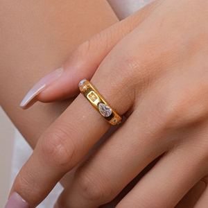Detailed close-up of a gold-plated teardrop zircon ring on a finger with luxury shine