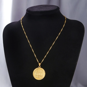 Detail of gold round pendant necklace featuring Arabic calligraphy on black mannequin