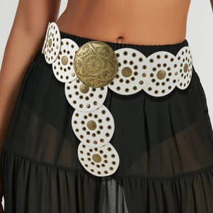 Detail of white leather disc belt with brass studs and ornate vintage floral buckle