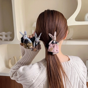 Close-up of handmade fabric rabbit hair ties in pink, khaki, and dark grey colors