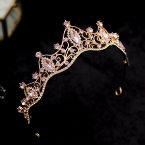 Detailed macro view of rose gold tiara featuring pink marquise-cut crystals on black velvet