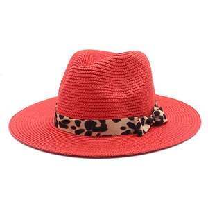 Red Panama straw hat with leopard print ribbon and bow detail on a white background