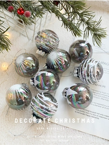 Close-up of sparkling 6cm iridescent Christmas balls with white glitter and festive lights