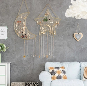 Detail of moon and star shaped golden metal wall grid for hanging earrings and jewelry