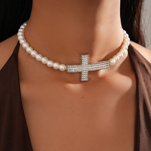 Close-up of pearl necklace with a sparkling rhinestone cross pendant on model