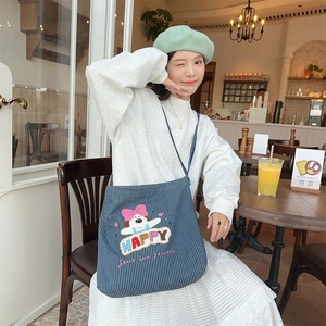 Close-up of a striped canvas crossbody bag with cute puppy embroidery and colorful letters