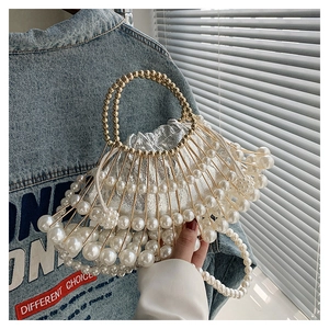 Detail of birdcage metal frame evening bag with white pearls and gold beaded handle