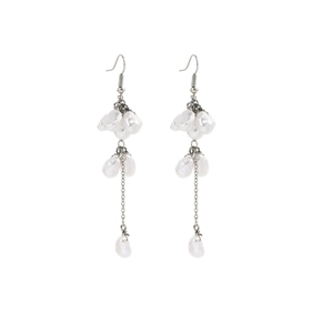 Close-up of long drop earrings with baroque pearls and silver metal chain tassels