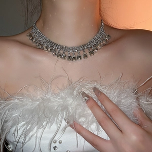 Elegant silver square geometric necklace with crystals on model with white feathers