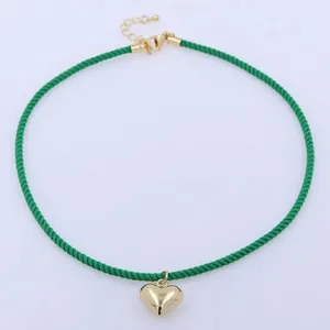 Dettaglio del girocollo in corda intrecciata verde con ciondolo a cuore dorato