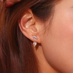 Close-up of 18K gold-plated teardrop and marquise zircon studs worn by a model