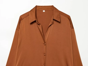 Detailed close-up of caramel satin shirt collar and buttons with smooth silk texture