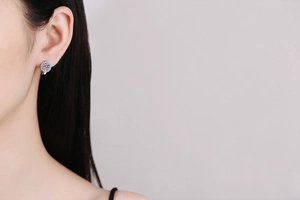 Detailed close-up of a sunflower-shaped moissanite stud earring worn by a model