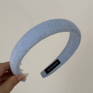 Detailed view of the soft blue terry cloth texture and handmade label on the headband