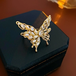Macro shot of gold-plated butterfly ring with pearls and zircons on a jewelry box