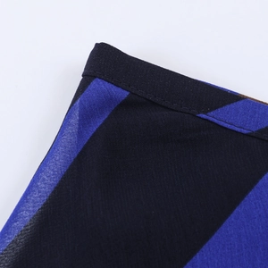 Detailopname van de geweven stof met donkerblauw en zwart geometrisch patroon en stiksels